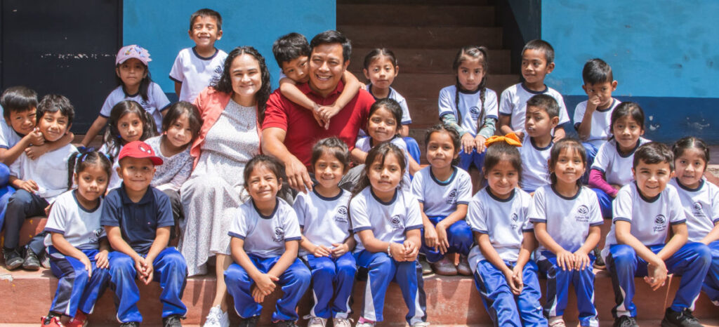 Hector and Ericka seated and surrounded by a bunch of Vida students