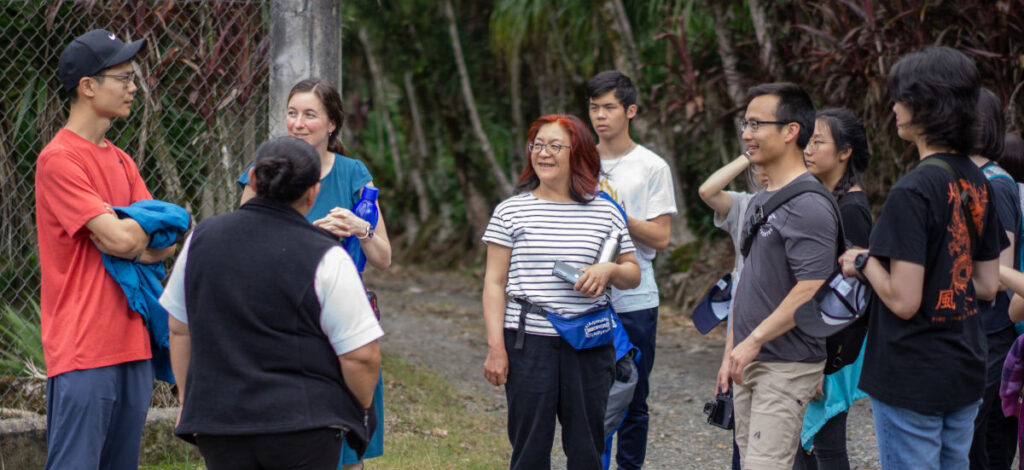 www.test.impactministries.ca Mission team members standing in a circle outside listening as Guatemalan missionary Julie shares